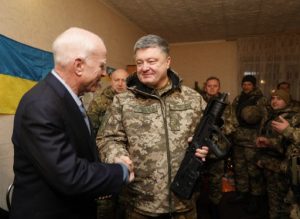 A handout photo released by the Ukrainian Presidential press service shows Ukrainian President Petro Poroshenko (R) presenting the Ukrainian award weapon to the Chairman of Senate Armed Services Committee, US Senator John McCain (L) during their working trip to the Donetsk region to congratulate the Ukrainian marines on the upcoming New Year in Shyrokine village on December 31, 2016. The President together with the delegation of the US Senators visited the frontline positions of the Ukrainian Naval Forces of Ukraine, which holds the defense line in Shyrokyne. / AFP PHOTO / UKRAINIAN PRESIDENTIAL PRESS SERVICE / MIKHAIL PALINCHAK / RESTRICTED TO EDITORIAL USE - MANDATORY CREDIT "AFP PHOTO / UKRAINIAN PRESIDENTIAL PRESS SERVICE / MIKHAIL PALINCHAK" - NO MARKETING NO ADVERTISING CAMPAIGNS - DISTRIBUTED AS A SERVICE TO CLIENTS